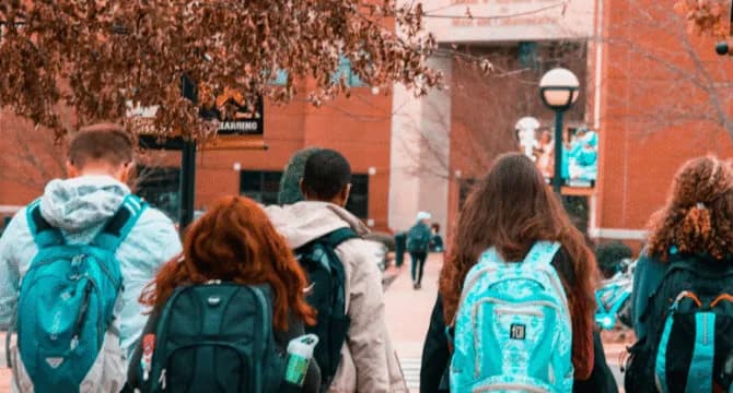 Students walking on campus with backpacks
