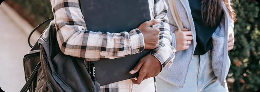 Students walking outdoors with backpacks and binders